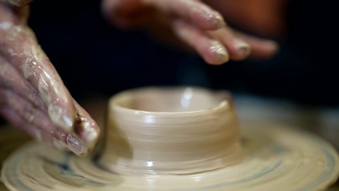 Close-up of the hands of a potter's wheel clay potter craft. Making pottery from clay