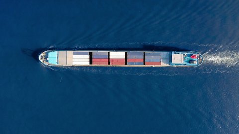 Aerial top view of cargo container ship. Huge cargo ship crossing the ocean. Concept freight shipping ship. Large Container Ship at Sea, Aerial Top Down View. 