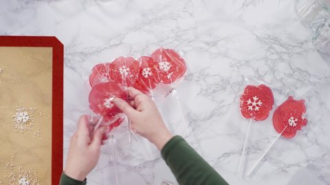 Flat lay. Wrapping large homemade lollipops into clear gift bags.