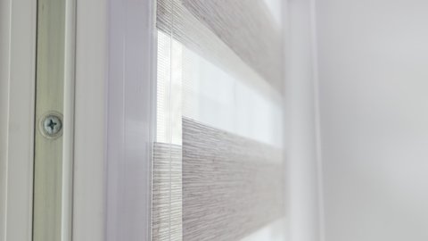 The mechanism of tnaninny roller blinds close up. Duo window roller system day and night. Close up on roller blinds indoors