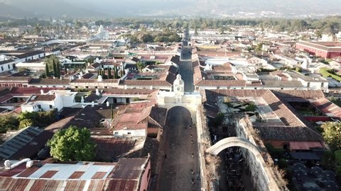 Aerial footage over the rooftops of Antigua, Guatemala with the surrounding volcanoes in the background