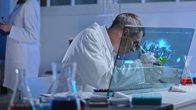 Lab worker watching chemical reaction under microscope and on holographic screen - Powered by Shutterstock - Get 15% off with code: PIKWIZARD15
