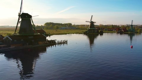Windmills at Zaanse Schans, aerial view. Famous place to visit in Amsterdam, Netherlands. Dutch Mills and typical Holland landscape in spring or summer, sunny weather.