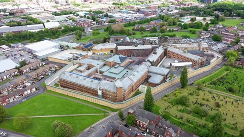 Aerial drone footage of the town of Armley in Leeds West Yorkshire in the UK, showing the famous HM Prison Leeds, or Armley Prison, showing the Jail walls from above on a sunny summers day.