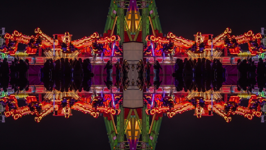 A timelapse of the lit up rides at a funfair in barcelona made into abstract mirrored pattern 