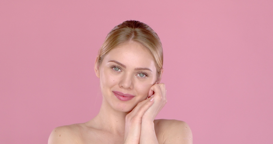 Young beautiful woman bare shoulders portrait. Posing isolated on pink background