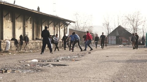Refugees and volunteers are playing football at the yard of a temporary refugee camp by an abandoned train station. Feb 22nd, 2017, Belgrade, Serbia.
