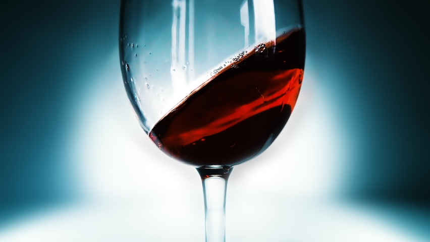 Creative macro slow motion 4k video of red wine splashing in a glass. Waving wine in a glass close-up. Filmed on high speed cinema camera. Royalty-Free Stock Footage #1090249945