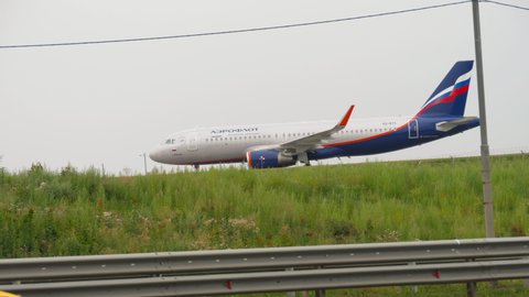 MOSCOW, RUSSIAN FEDERATION - JULY 28, 2021: Airbus A320, VQ-BTX Aeroflot taxis to the terminal after landing at Sheremetyevo airport. Taxiway along the highway