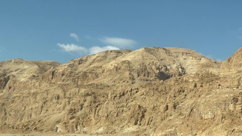 Dead sea mountain dunes picturesque view from a driving car window - 4k cinematic ungraded