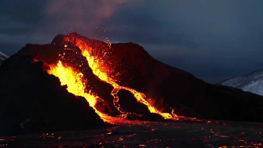 Close-up view of erupting volcano in Geldingadalir near Fagradalsfjall mountain, Grindavík, Reykjanes peninsula, southwestern Iceland with explosions of hot, glowing lava in the evening. Royalty-Free Stock Footage #1090251665