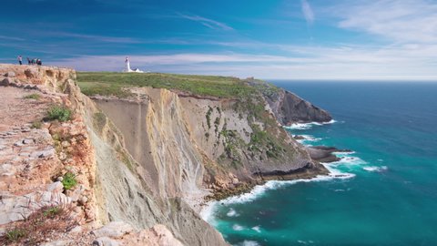 Lighthouse of Cape Espichel with moving clouds near Atlantic ocean, view from the temple, Portugal panoramic timelapse