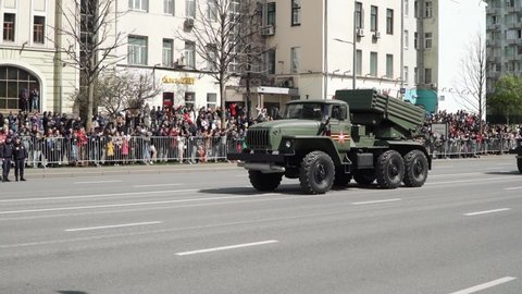 MOSCOW, RUSSIA - May 9, 2022: Grad Soviet and Russian multiple launch rocket system of 122 mm caliber. Spectators and military equipment traveling from the parade dedicated to the 77th anniversary of