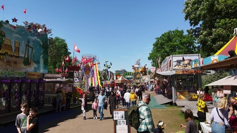 BERLIN, GERMANY - MAY 15, 2022: Crowded Fun Fair, Carnival Neuköllner Maientage with carnival rides and concession stands in the public park Hasenheide.