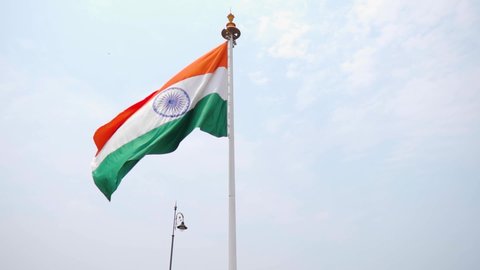 Slow motion shot of an Indian flag waving in front of the blue sky at Goa in India. Indian flag waving in the wind. Indian flag background. Indian flag waves in front of the blue sky during day time. 