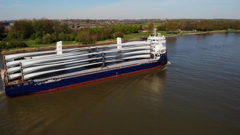 Barendrecht , Netherlands - 04 18 2022: Drone View Of Symphony Provider Cargo Ship Transporting Transporting Wind Turbine Propeller Blades Along Oude Maas 