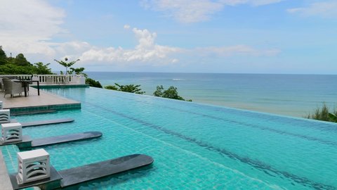 Swimming pool in modern tropical resort. Infinity view pool with sea view and green hills on Phuket island, Thailand. Summer retreat and vacation