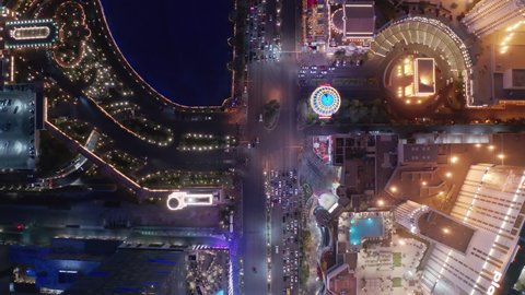 Aerial 4K top down view traffic Las Vegas Strip blvd with vibrant colorful night illumination of modern resorts and casinos buildings, Bellagio fountain, pink Flamingo hotel. Las Vegas, USA Apr 2022