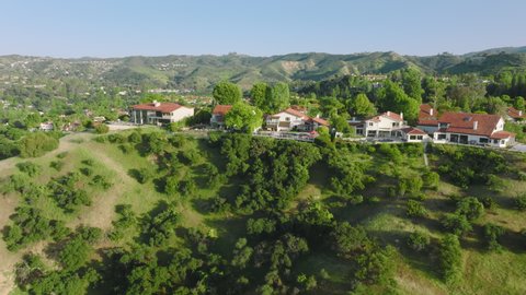 Drone footage of the light and bright airy home within tranquil landscape. Beautiful mansion in Calabasas Park for the perfect retreat as seen from above. High quality 4k footage