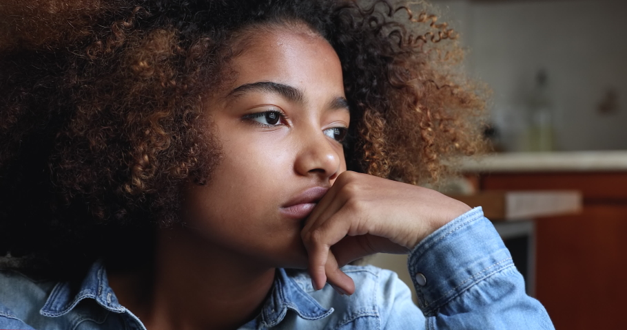 Close up face of sad looking pensive Black teen female suffer of loneliness depression at home feel heartbroken after destructive relationship with abuser. Unhappy vulnerable young lady coping stress Royalty-Free Stock Footage #1090263793