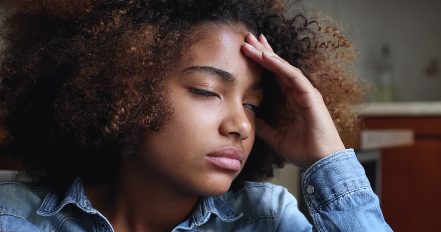 Close up face of sad looking pensive Black teen female suffer of loneliness depression at home feel heartbroken after destructive relationship with abuser. Unhappy vulnerable young lady coping stress Royalty-Free Stock Footage #1090263793