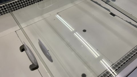 Empty display-type refrigerator in a supermarket during a crisis or food shortage. Closeup