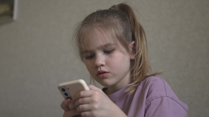 A little girl is engaged online in the application on the phone. learning foreign languages in a playful way for children on a smartphone. | Shutterstock HD Video #1090265399