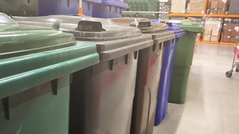 New outdoor plastic dumpsters (trash cans) stand in rows in home improvement store (DIY store)