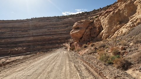 Moki Dugway Utah mountain man jogging POV. Roadway carved from a mountain cliff. Scenic Backway a stretch of Highway 261 switches down the side of a cliff is an 11% grade and very narrow.