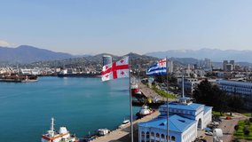 The flag of Georgia is fluttering in the wind.  Sea port in Batumi.
