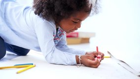 Cute little African American girl in casual clothing drawing and painting with color pencils in the room at home - Powered by Shutterstock - Get 15% off with code: PIKWIZARD15