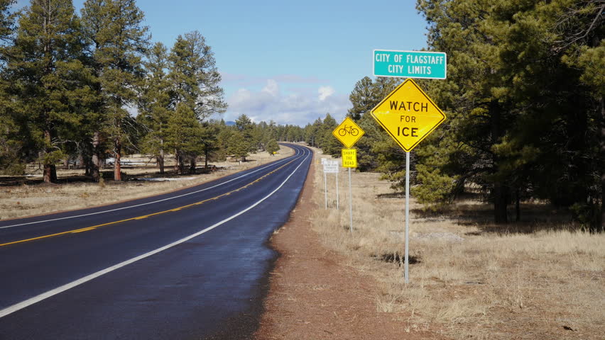 Car driving on a highway, passing Welcome to Flagstaff sign. 4K UHD.