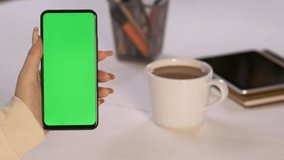 Handheld Camera: Back View of Brunette woman Holding Chroma Key Green Screen Smartphone Watching Content Without Touching or Swiping