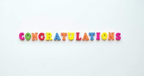 Text Congratulations from colorful wooden letters and a confetti around. 4K looped stop motion animation