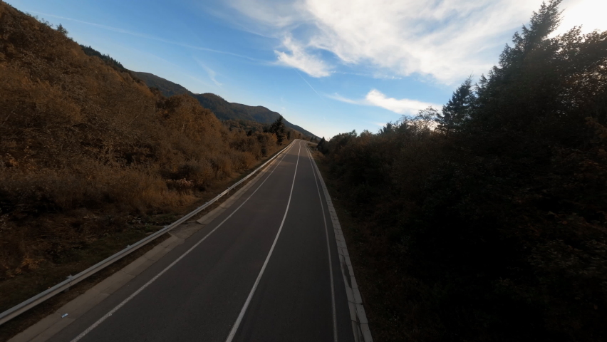 Motion FPV video of lonely motorcycle rider driving on empty highway in picturesque natural landscape. Concept for freedom, movement and travel. Royalty-Free Stock Footage #1090277659