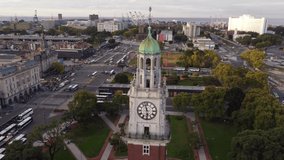 Aerial drone orbiting around English clock tower front to Retiro Station in Buenos Aires City with port in background, Argentina