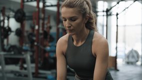 Young woman having a break at the gym while holding a bottle of water. Shot with RED helium camera in 8K. 