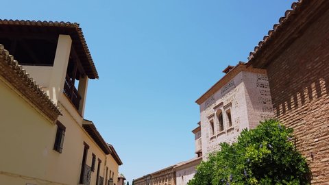 Alhambra, Granada, Spain - July 18 2019 : The distinctive brick works of both the Church of Santa Maria and the Palace of Charles V buildings.