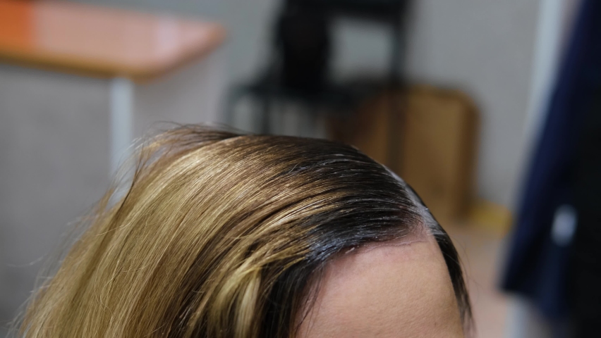 Hairdresser paints gray hair roots with brush. Hair coloring close-up. Slow motion | Shutterstock HD Video #1090284177