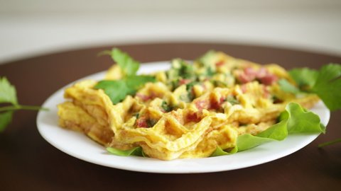 Egg omelet stuffed with greens and sausage fried in the form of waffles