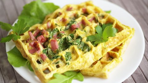 Egg omelet stuffed with greens and sausage fried in the form of waffles