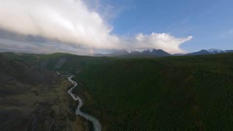 Aerial view majestic rainbow natural mountain river water flow darkness landscape sky horizon hilly terrain. FPV sport drone shot picturesque nature cliff scenery canyon with pine spruce forest in 4k