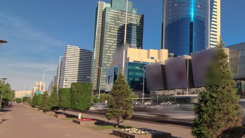 New business district timelapse hyperlapse on Boulevard with traffic on road and green modern towers in the capital of Kazakhstan in Astana. Nur-Sultan city