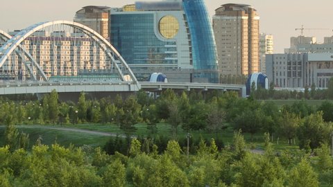 Panorama of the Astana city before sunset timelapse with bridge and buildings. View over the park from the Palace of Peace and Reconciliation. Nur-Sultan city, Kazakhstan