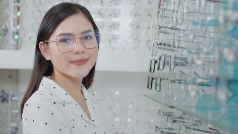 Young female customer choosing glasses in optical center, Eye care concept.

