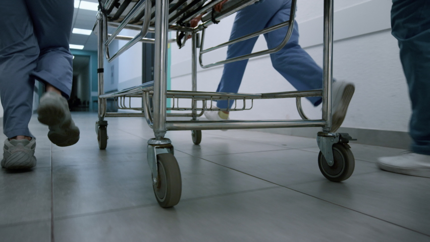 Doctors feet running down hospital corridor with gurney close up. Unknown medics team moving quickly to emergency room. Medical professionals pushing stretcher hurrying on operation. Health concept. Royalty-Free Stock Footage #1090290915
