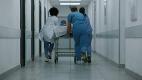 Unknown doctors team running down hallway rolling gurney back view. Medical staff hurrying to hospital surgery in blue uniform. Professional medics carrying patient stretcher to emergency room doors. - Powered by Shutterstock - Get 15% off with code: PIKWIZARD15