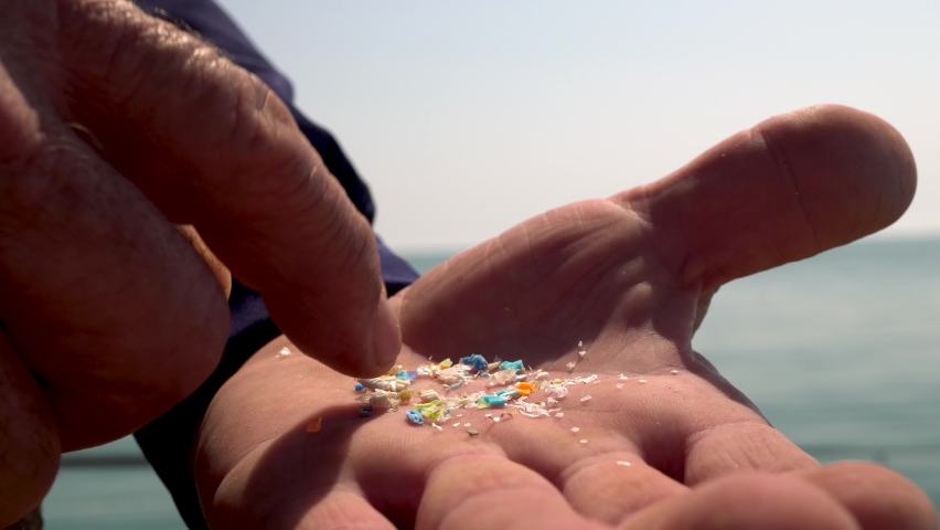 Close-up shot of microplastics particles on the fingers of a volunteer. The concept for water pollution and global warming. Climate change idea. Soft focus of micro plastic that cannot be recycled | Shutterstock HD Video #1090292071