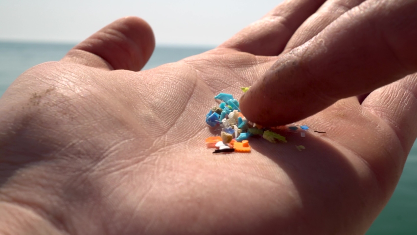 Close-up shot of microplastics particles on the fingers of a volunteer. The concept for water pollution and global warming. Climate change idea. Soft focus of micro plastic that cannot be recycled | Shutterstock HD Video #1090292075