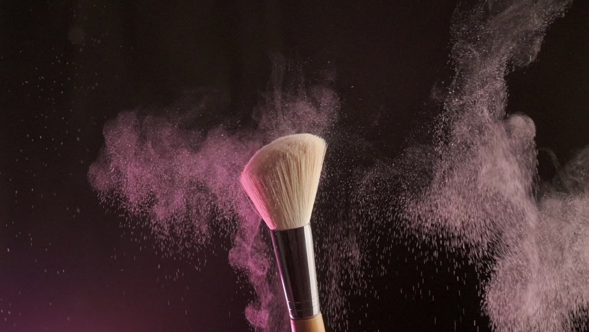 Close up selective focus shot of shimmer powder being shaken off makeup brush | Shutterstock HD Video #1090293627